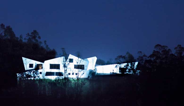 Una casa blanca de noche, con las luces encendidas